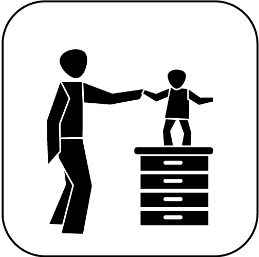 Silhouette eines Erwachsenen, der ein Kind auf einem Tisch unterstützt, während das Kind steht und balanciert.